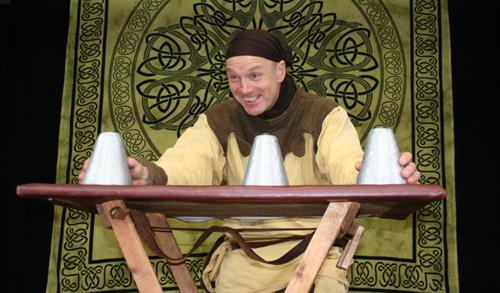 Cyrano als mittelalterlicher Zauberer mit Becherspiel auf einer Bühne in Bochum